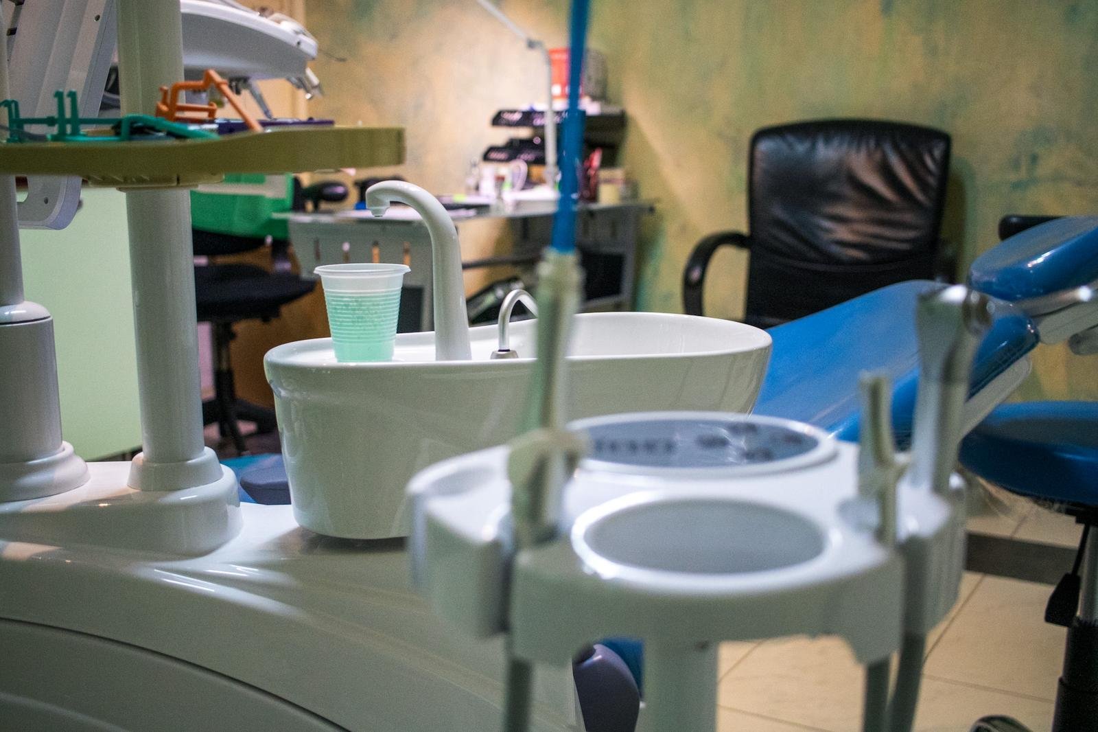 Prepared instrument tray and cuspidor on a dental unit at Lux Dental Clinic