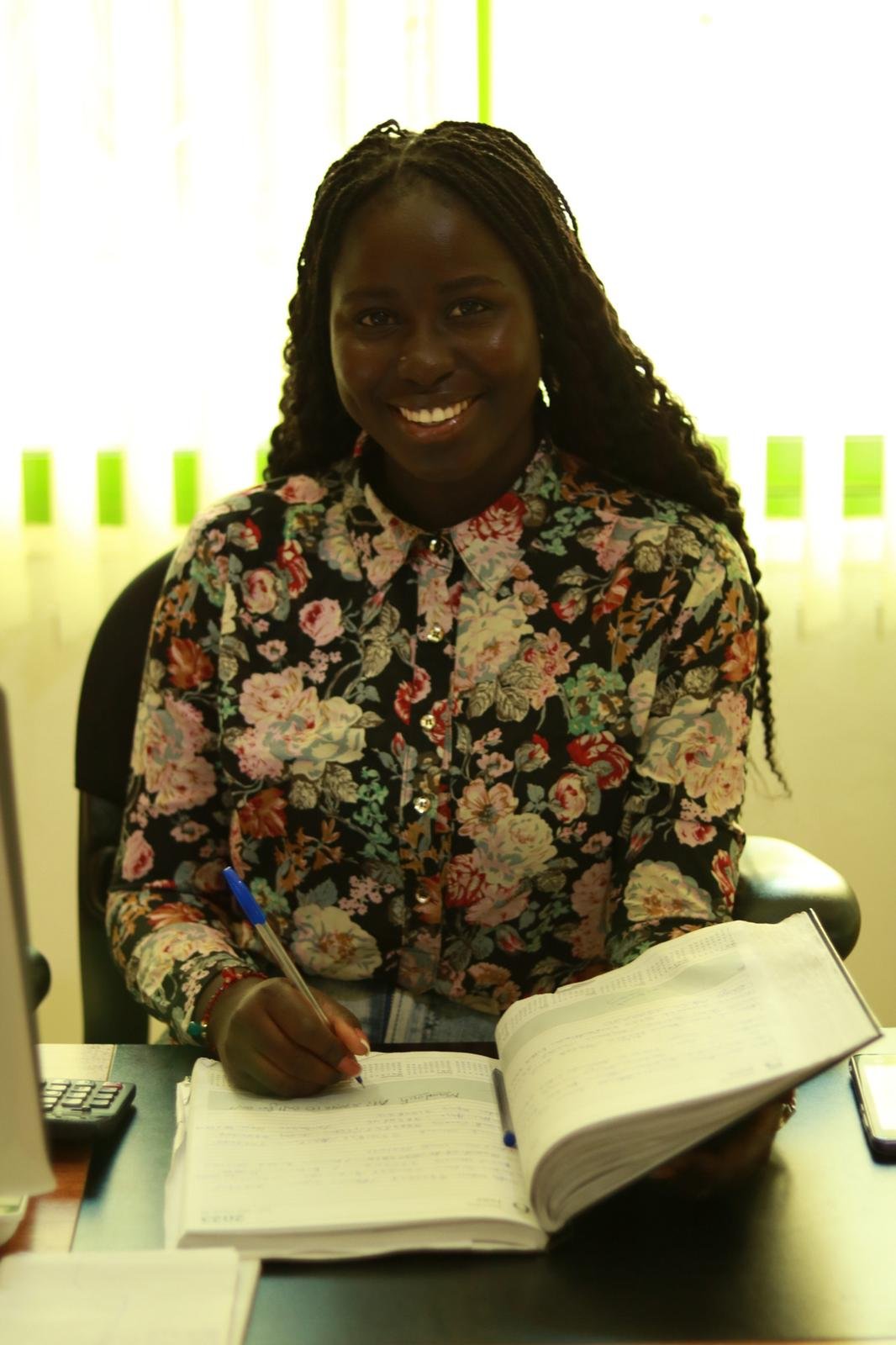 Patient coordinator at the Lux Dental Clinic reception desk with the appointment book