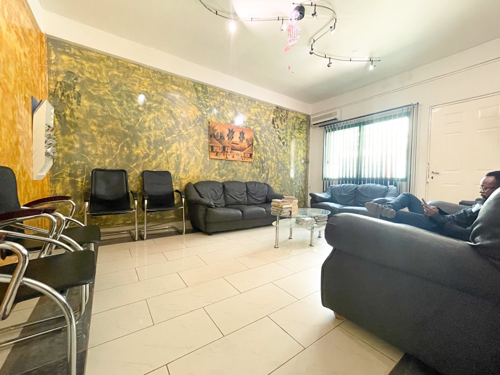 Air-conditioned waiting room at Lux Dental Clinic with sofas and natural light